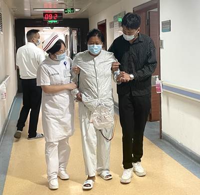 术后,护理人员与家属帮助达瓦母亲下床活动